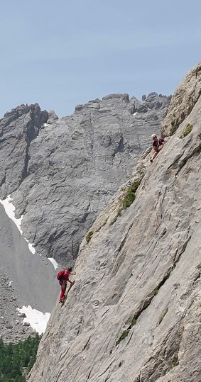 2 personne grimpe sur une dalle en montagne
